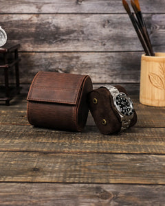 Removable watch cushion with two side snaps displayed beside the closed brown watch roll.