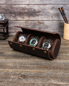 Espresso triple watch roll open on a wooden table with three watches on individual cushions.