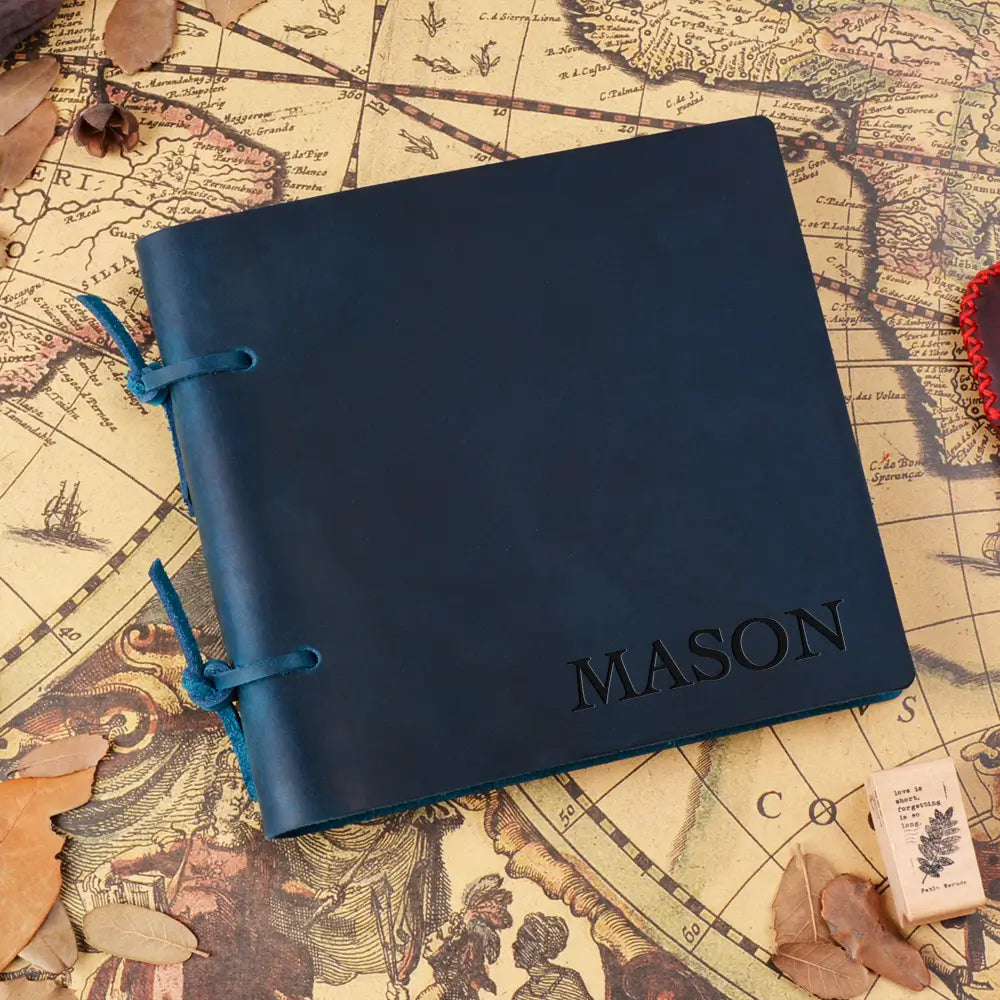 Blue leather notebook with 'MASON' engraving on an old map background