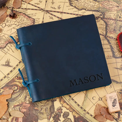 Blue leather notebook with 'MASON' engraving on an old map background
