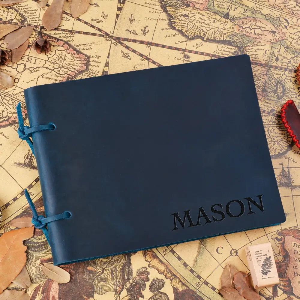 Blue notebook with 'MASON' embossed on it, placed on an old map.