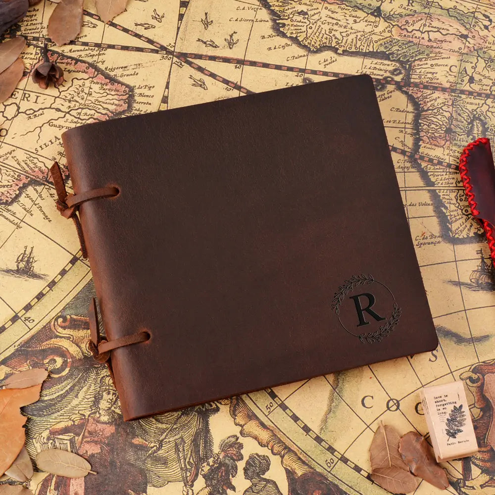Brown leather notebook with a monogram on an old map background