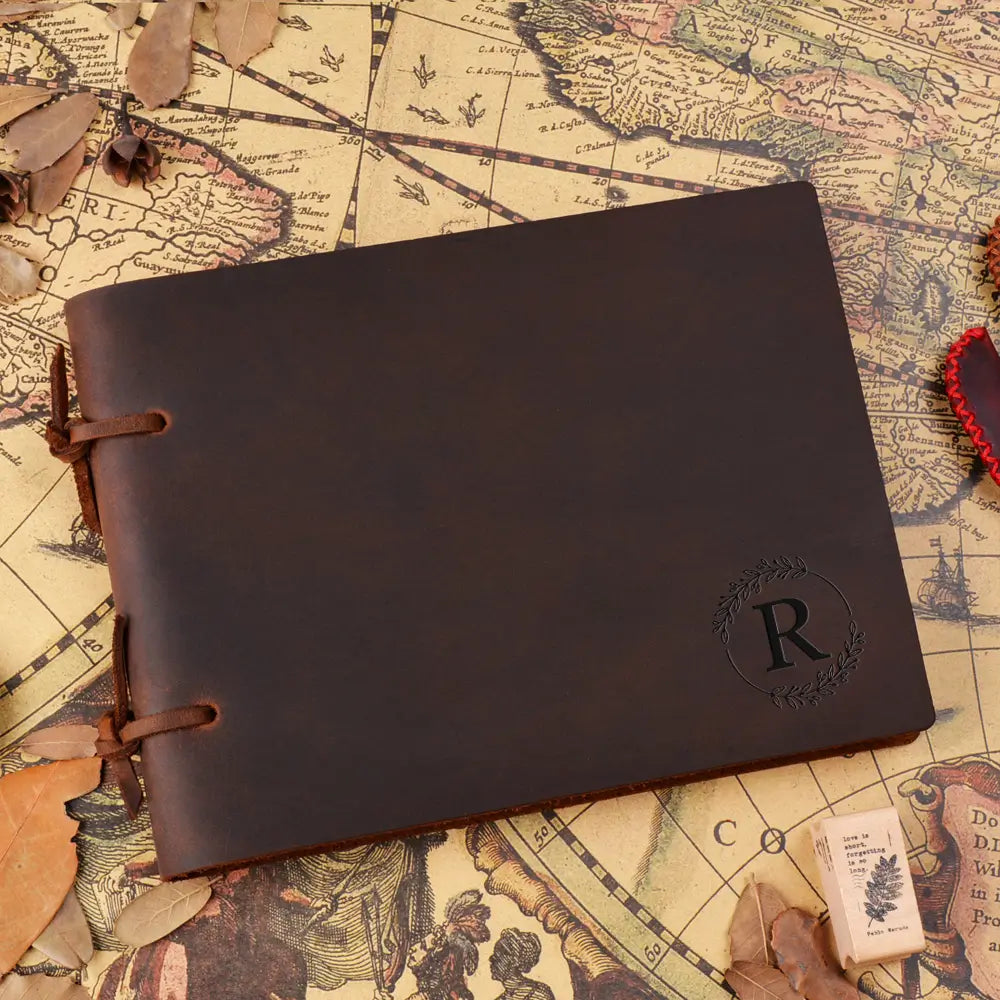 Brown leather notebook with a monogram on an old map background