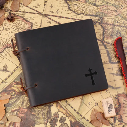 Black leather notebook with a cross on a vintage map background