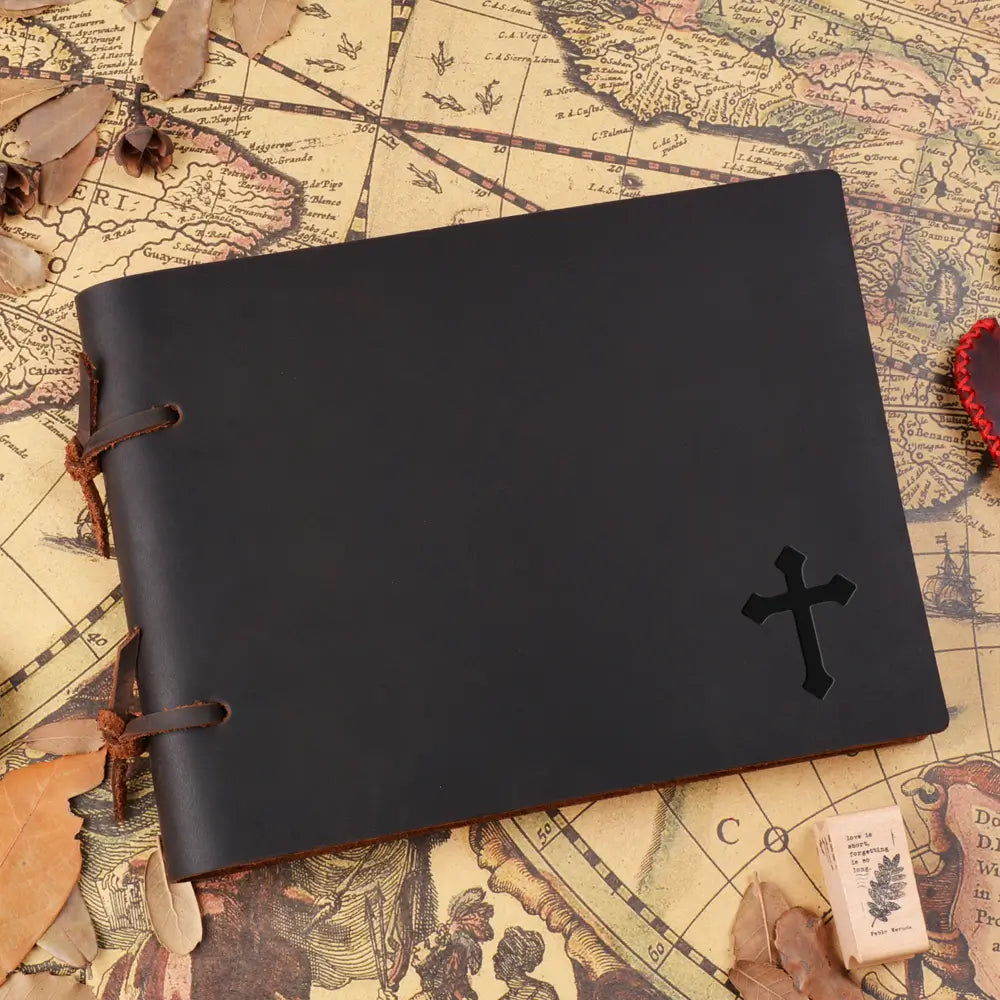 Black leather notebook with a cross design on an old map background
