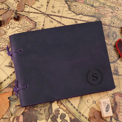 Purple leather notebook with a monogram on an old map background