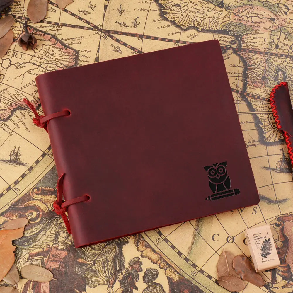 Red notebook with owl emblem on a vintage map background