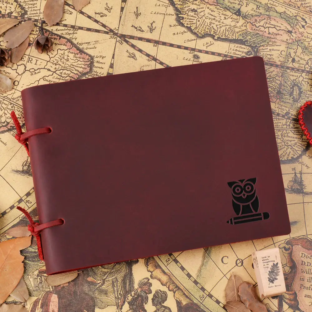 Maroon notebook with owl design on a vintage map background
