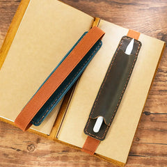 Pen inserted in leather holder on journal cover