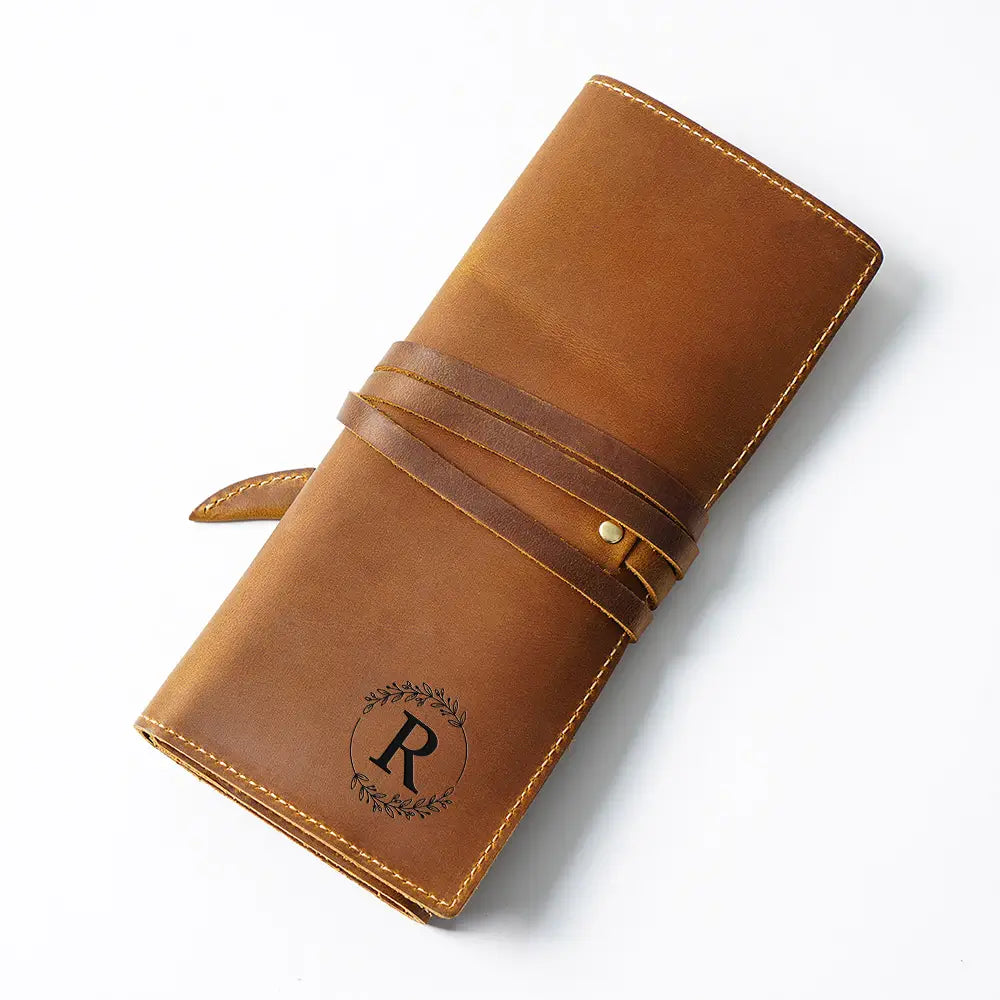 Brown leather pen case with a monogram on a white background