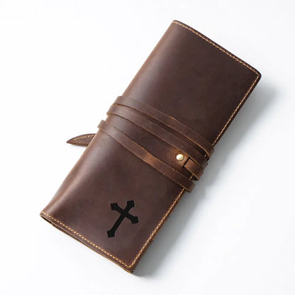 Brown leather pen case with a black cross emblem on a white background