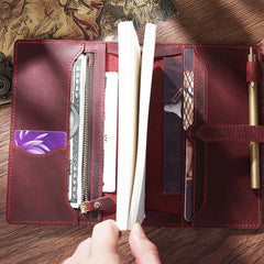 Person writing in personalized leather journal on wooden desk